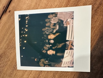 A Den gathering under string lights